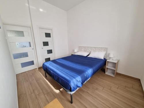 sypialnia z niebieskim łóżkiem w białym pokoju w obiekcie Raggio di sole w mieście Napoli