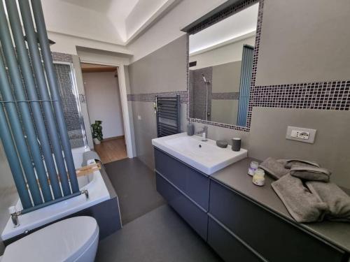 W łazience znajduje się umywalka, toaleta i lustro. w obiekcie Raggio di sole w mieście Napoli