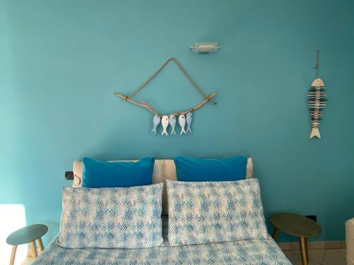 a bedroom with blue walls and a bed with blue pillows at Bellagio lake flat in Bellagio
