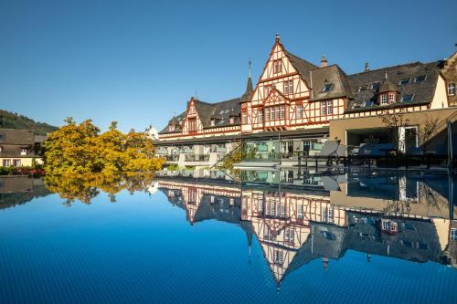 un grande edificio con riflessione nell'acqua di Moselschlösschen Spa & Resort a Traben-Trarbach