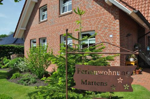 a garden sign in front of a brick house at Ferienwohnung Martens 65344 in Moormerland