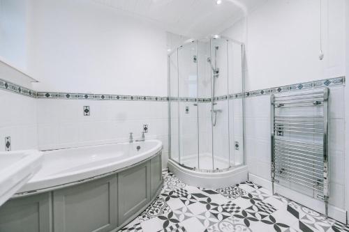 ein weißes Bad mit einer Badewanne und einer Dusche in der Unterkunft Norton Village View By Horizon Stays in Stockton-on-Tees