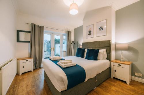um quarto com uma cama grande e almofadas azuis em Norton Village View By Horizon Stays em Stockton-on-Tees