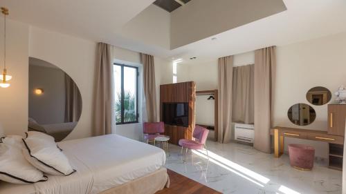 ein Hotelzimmer mit einem Bett und einem TV in der Unterkunft VILLA INGRID 12, Emma Villas in Santa Venerina