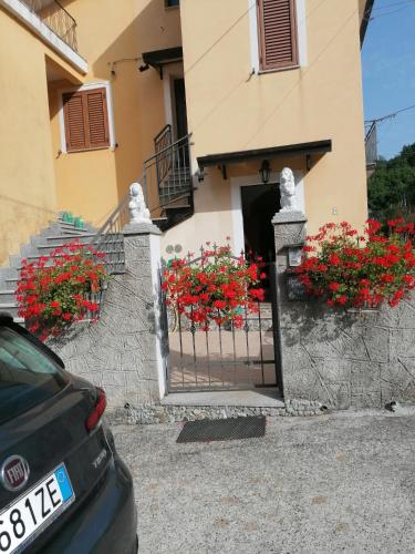 ein Tor vor einem Gebäude mit roten Blumen in der Unterkunft La casa di Pina in Latronico