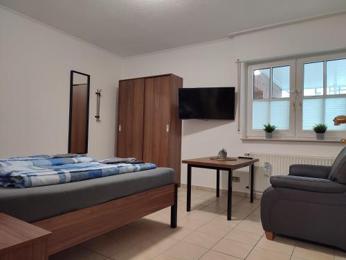 - une chambre avec un lit, une télévision et un canapé dans l'établissement Tempel-inn Klosterstraße, à Haselünne