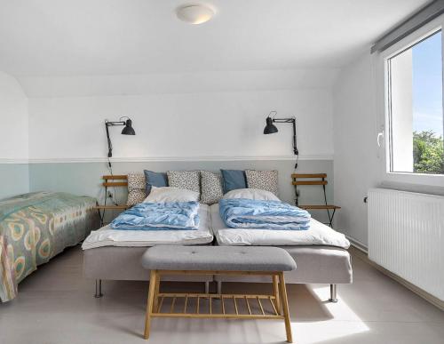 dwa łóżka w pokoju z oknem w obiekcie Tante Tut & Onkel E - B & B - Hotel w mieście Kolby Kås