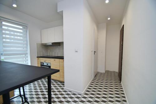 uma cozinha com uma mesa preta e um piso preto e branco em Apartament Bytkowska em Katowice