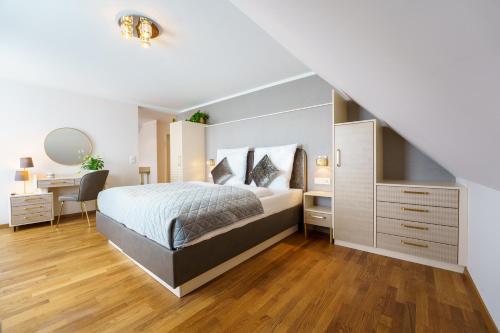 - une chambre blanche avec un lit et un bureau dans l'établissement Hotel Wilder Mann, à Meersburg