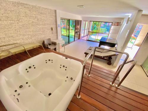 Habitación con escritorio y bañera grande. en Condomínio Mediterranee Residence por Be My Guest, en Aquiraz