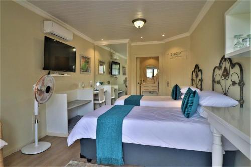 a bedroom with a large bed and a bathroom at The Ranch Guesthouse in Potchefstroom