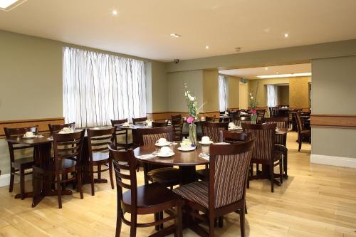 a dining room with wooden tables and chairs at Phoenix Hotel in London