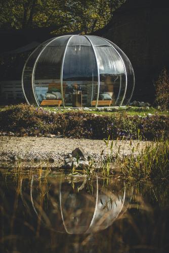 a dome tent sitting next to a body of water at Tornácos Hotel - Hegykő in Hegykő