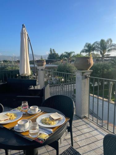 una mesa con platos de comida en el balcón en Hotel Villa Ruggiero en Brusciano