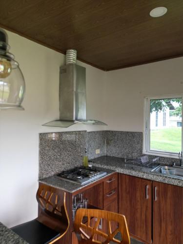 a kitchen with a stove and a sink and a window at Casita Boquete in Boquete
