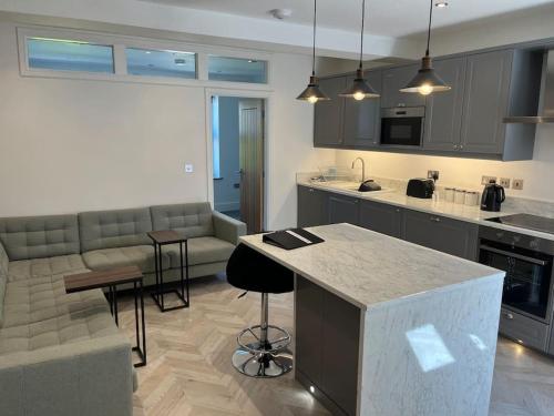 a kitchen and living room with a couch and a table at Jester Court - 2 bed apartment in the Centre of Windermere Village - FREE off-site Health Club access with Pool, Sauna, Steam Room & Gym in Windermere