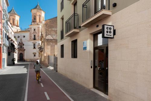 une personne à vélo dans une rue dans l'établissement Coeo Apart-Hotel Parras, à Malaga