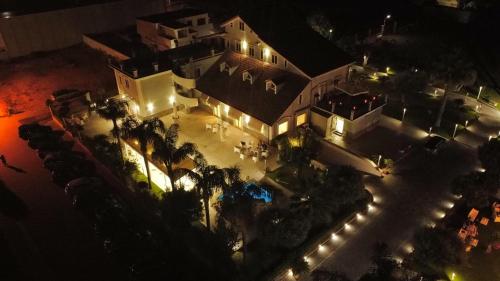 - une vue aérienne sur un bâtiment la nuit avec des lumières dans l'établissement Hotel Villa Ruggiero, à Brusciano