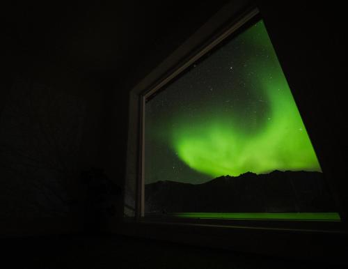 ein Bild der Aurora durch ein Fenster gesehen in der Unterkunft Polar Panorama Lodge in Fjordgård
