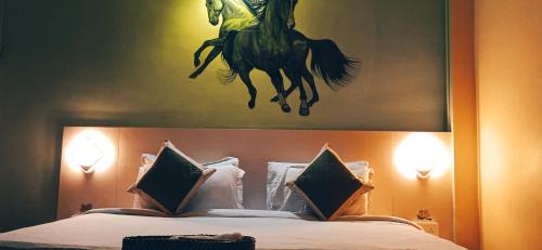 a painting of a man riding a horse on a bed at Tridhara HomeStay in Guwahati