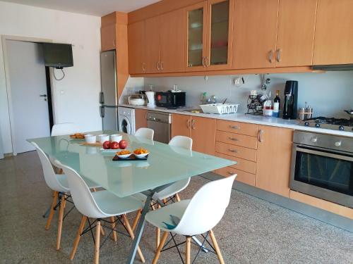 uma cozinha com uma mesa e cadeiras brancas em 3 bedrooms villa with city view private pool and enclosed garden at Sao Miguel do Prado 