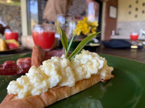 a green plate with a piece of bread with eggs on it at Rosewood Manor in Botiyatenna