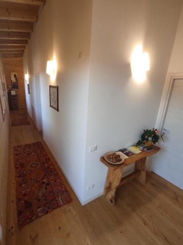 a hallway with a table in a room with white walls at Agriturismo La Soglia Del Parco in Ranica