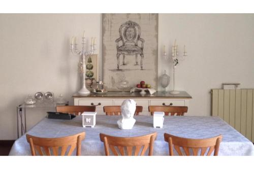 un comedor con una mesa con sillas y una estatua en La Butterfly Guest apartment, en Lucca