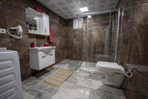 een badkamer met een douche, een toilet en een wastafel bij ABC Apart Hotel in Antalya