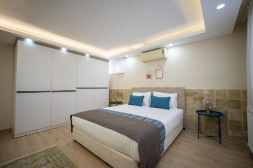 een slaapkamer met een groot bed met blauwe kussens bij ABC Apart Hotel in Antalya
