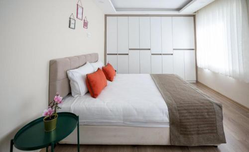 a bedroom with a bed with orange pillows and a table at ABC Apart Hotel in Antalya