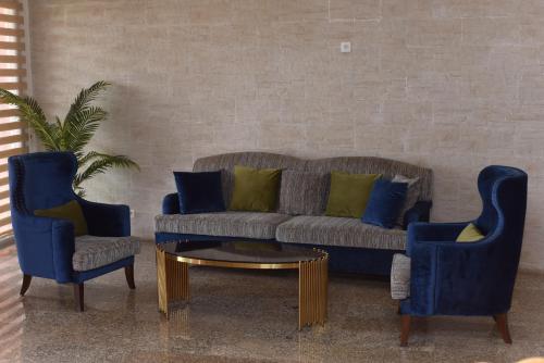 a living room with a couch and two blue chairs at Le Feto 2 in Dakar