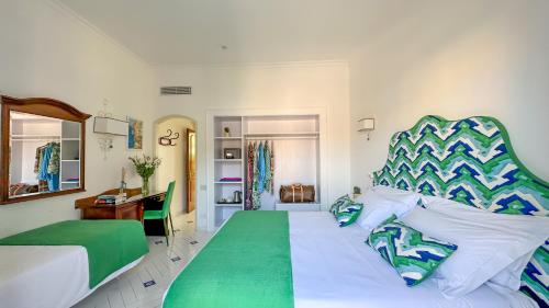 a bedroom with a green and white bed and a desk at Hotel Villa Di Sorrento in Sorrento