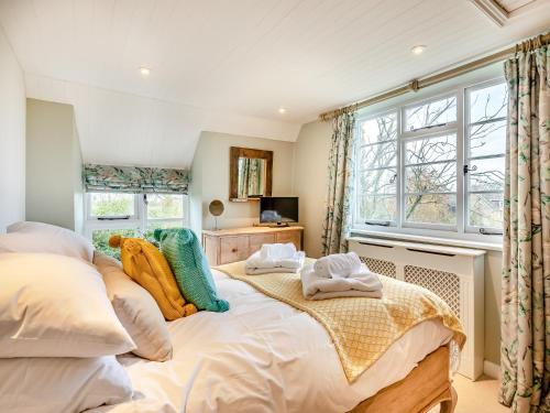 um quarto com uma cama grande e uma janela em Bridge Cottage em High Ham