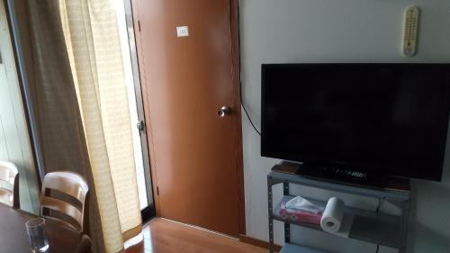 a room with a television and a door with a window at Minshuku Chatamago in Nagasaki