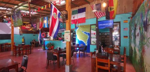 a restaurant with tables and chairs and flags on the wall at Hotel Aldea Pura Vida in Puntarenas