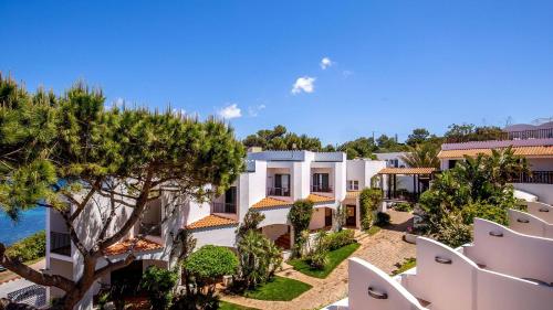 an image of a villa with the ocean in the background at El Faro Hotel & Spa in Porto Conte