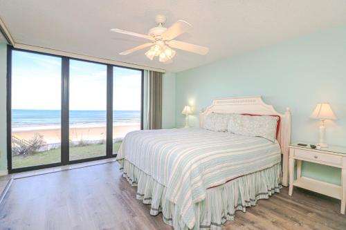 Un dormitorio con una cama con vistas a la playa. en Sand Dollar 2-201, en St. Augustine
