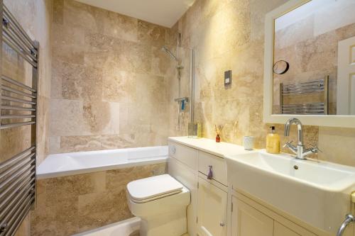 a bathroom with a sink and a toilet and a tub at Apartment 4 - The Kings in York