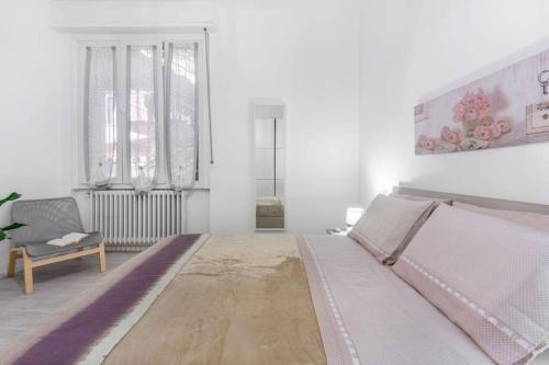 ein weißes Zimmer mit einem Bett und einem Stuhl in der Unterkunft ELLE Boutique [Milano-Lissone-Monza] in Lissone