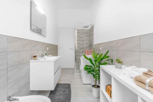 La salle de bains blanche est pourvue de toilettes et d'un lavabo. dans l'établissement ELLE Boutique [Milano-Lissone-Monza], à Lissone