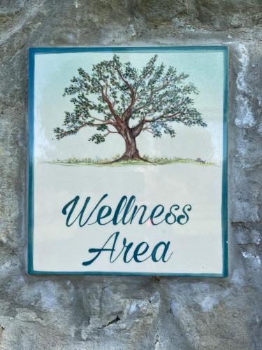 a sign hanging on a wall with a tree at Villa Ghiandai in Arezzo