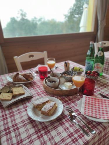 a table with plates of food and glasses of orange juice at Agriturismo La Soglia Del Parco in Ranica