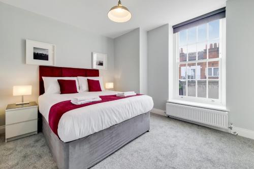 Un dormitorio con una cama grande y una ventana en Roomspace Serviced Apartments - Brewers Lane, en Richmond
