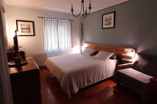 a bedroom with a bed and a desk and a window at La Casa del Rio. in La Serna