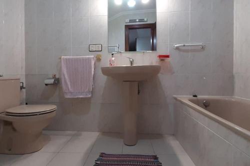a bathroom with a sink and a toilet and a tub at La Casa del Rio. in La Serna