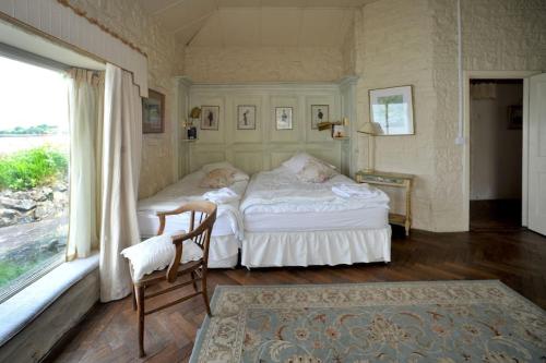 two beds in a room with a window at Wood Quay - A truly unique, seafront experience! in Carlingford