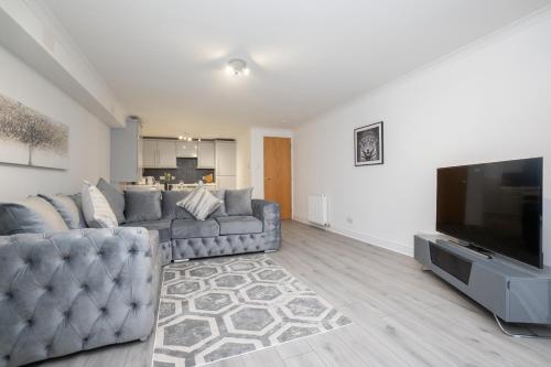 a living room with a couch and a flat screen tv at Panacotta House - Luxury 1 Bed Apartment in Aberdeen in Aberdeen