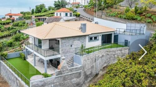 an aerial view of a house with a stone wall at House - sleeps 3 free parking garden & jacuzzi in Estreito da Calheta