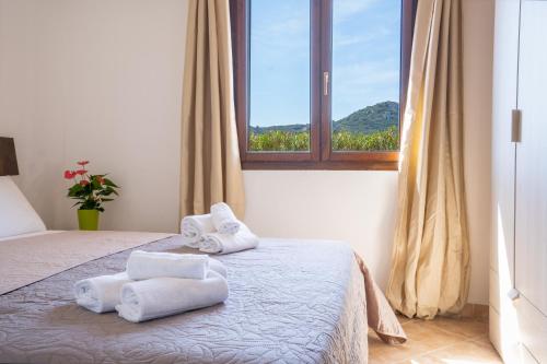 una camera da letto con due asciugamani su un letto con finestra di Residence La Falata Costa Paradiso a Costa Paradiso